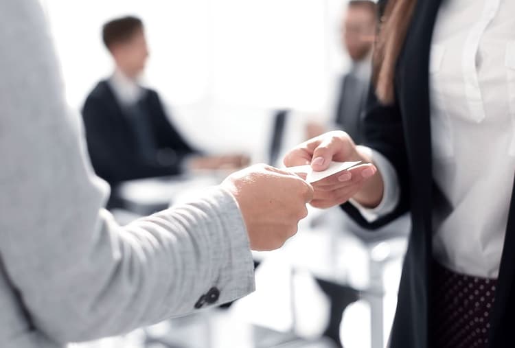 Two business people exchanging a card.